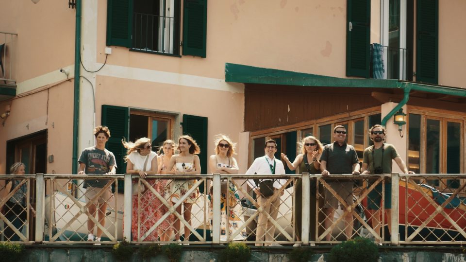 A group of people standing on a bridge next to a building